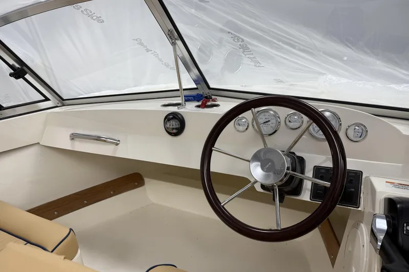 Slide: The Image of 2022 Rossiter 17 Closed Deck boat interior with steering wheel and dashboard controls. - 12