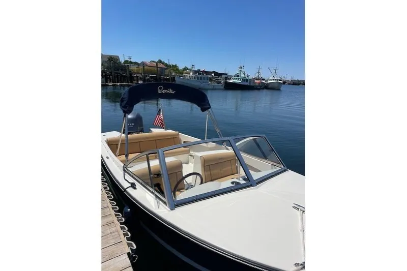 Slide: The Image of 2022 Rossiter 17 Closed Deck boat docked in a serene marina setting. - 3
