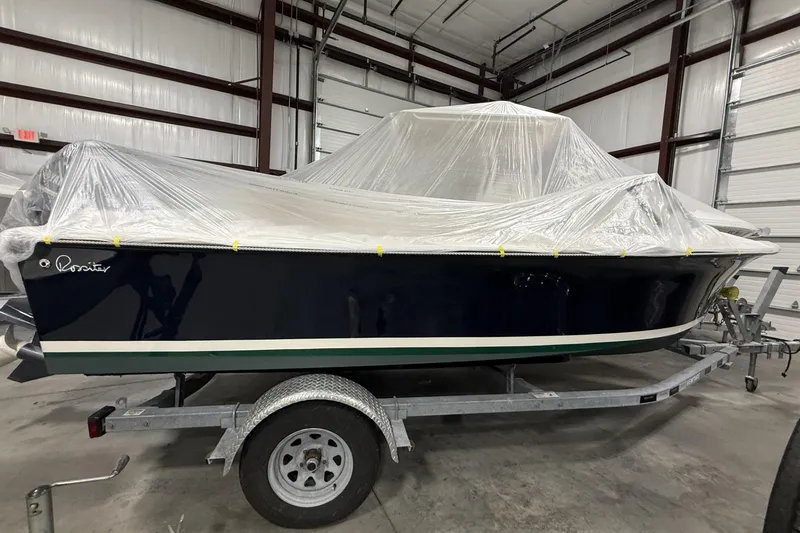 Slide: The Image of 2022 Rossiter 17 Closed Deck boat covered in plastic, stored indoors on a trailer. - 5