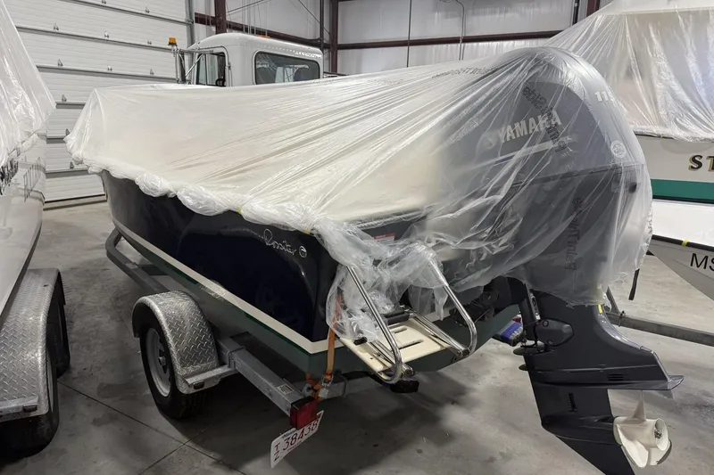 Slide: The Image of 2022 Rossiter 17 Closed Deck boat with Yamaha engine, covered in plastic, on trailer in storage. - 6