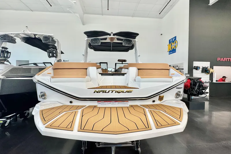 Slide: The Image of 2026 Nautique Super Air Nautique G23 boat in showroom, rear view with tan seating. - 3
