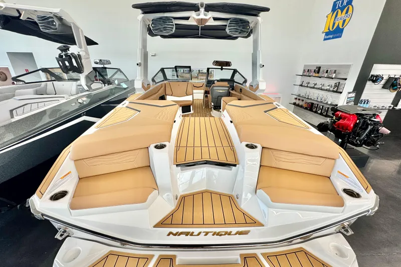 Slide: The Image of 2026 Nautique Super Air Nautique G23 boat with tan seating and sleek design in showroom. - 4