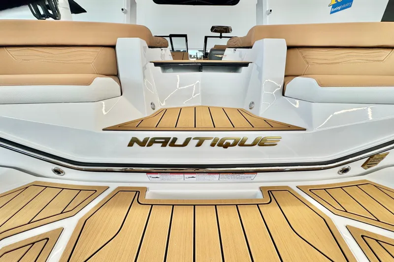 Slide: The Image of 2026 Nautique Super Air Nautique G23 boat interior with tan seating and teak flooring. - 5