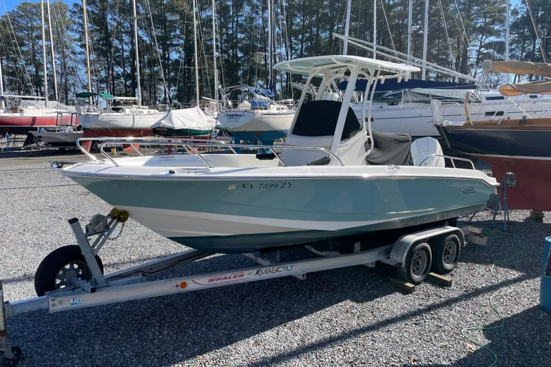 The Image of 2023 Boston Whaler 220 Dauntless boat on trailer in marina setting. - 0