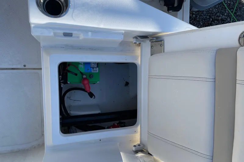 Slide: The Image of 2023 Boston Whaler 220 Dauntless boat storage compartment with visible battery and seating. - 14