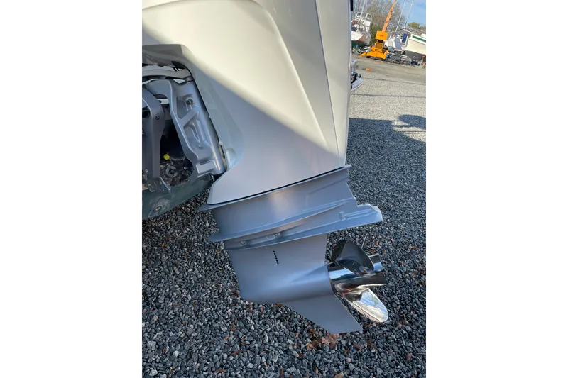 Slide: The Image of 2023 Boston Whaler 220 Dauntless boat engine and propeller on gravel surface. - 6