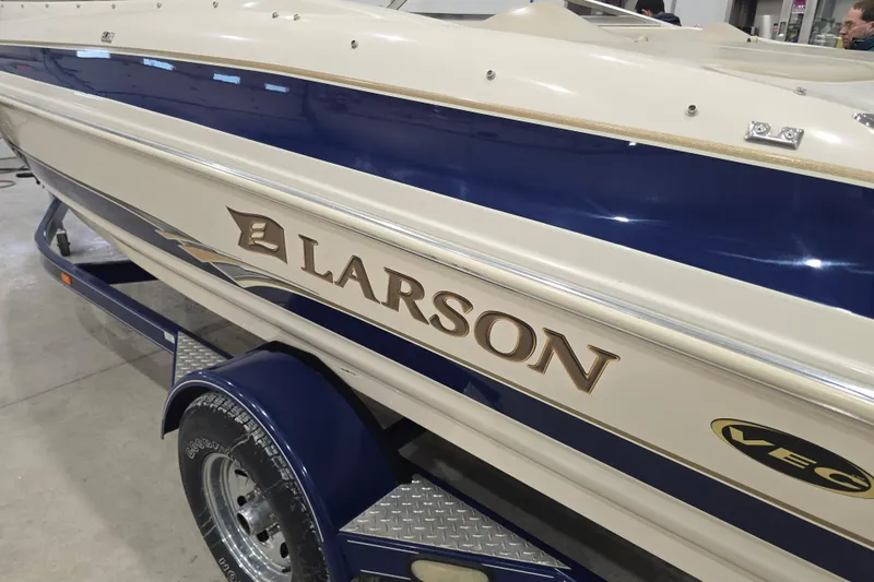 Slide: The Image of 2004 Larson LXi 190 boat with blue and white exterior on a trailer. - 11