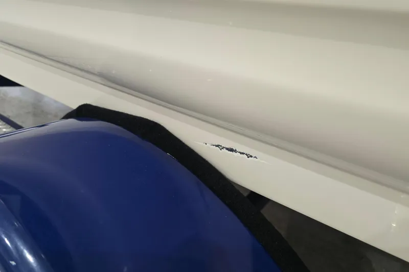 Slide: The Image of 2004 Larson LXi 190 boat with hull scratch near blue fender. - 12