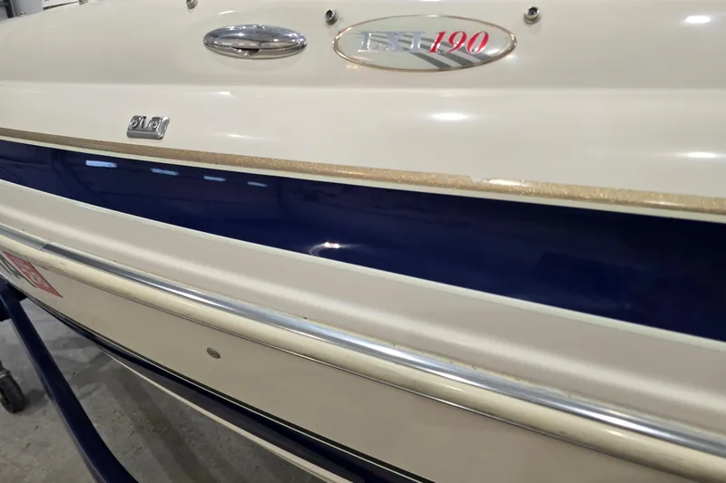 Slide: The Image of 2004 Larson LXi 190 boat side view with blue and white detailing. - 14