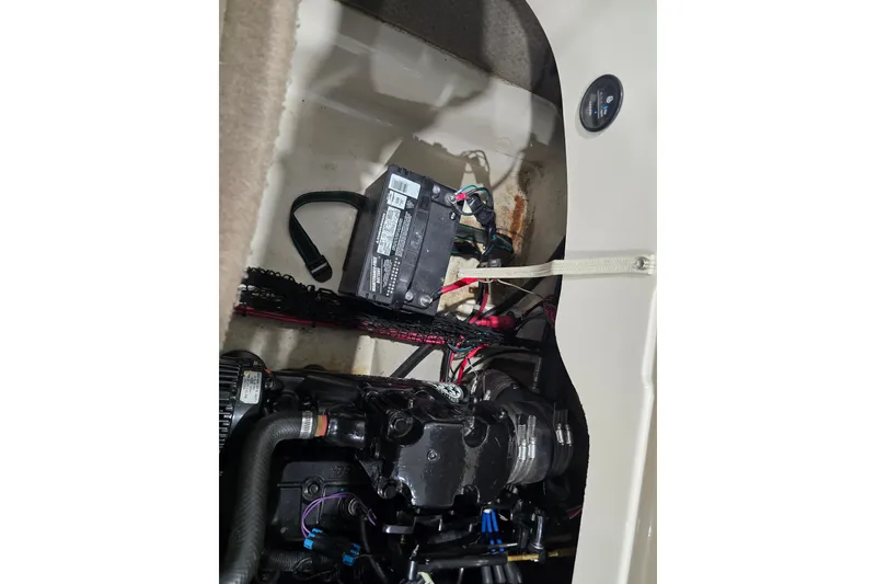 Slide: The Image of Engine compartment of a 2004 Larson LXi 190 boat, showing battery and wiring. - 17