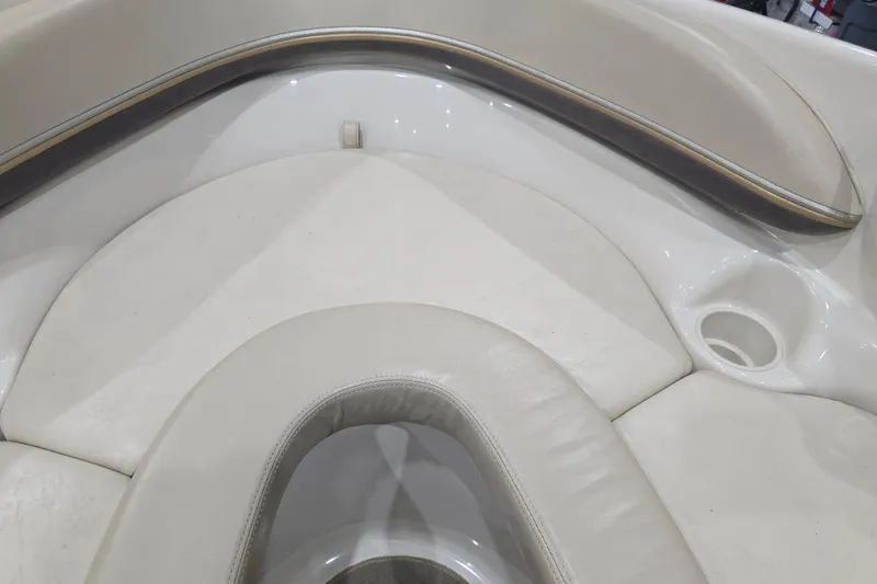 Slide: The Image of 2004 Larson LXi 190 boat interior with white cushioned seating and cup holder. - 22