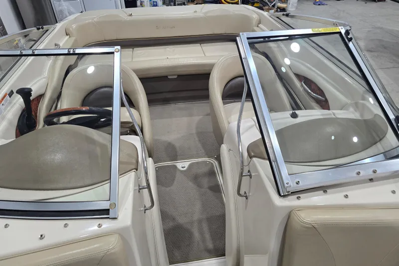 Slide: The Image of 2004 Larson LXi 190 boat interior with beige seating and dual windshields. - 24