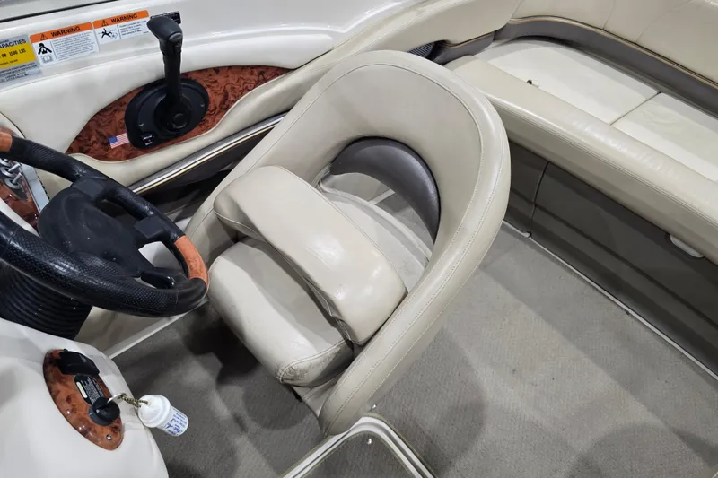 Slide: The Image of 2004 Larson LXi 190 boat interior with steering wheel and beige seating. - 26