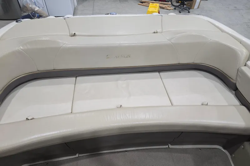 Slide: The Image of 2004 Larson LXi 190 boat interior with beige seating in a garage setting. - 28