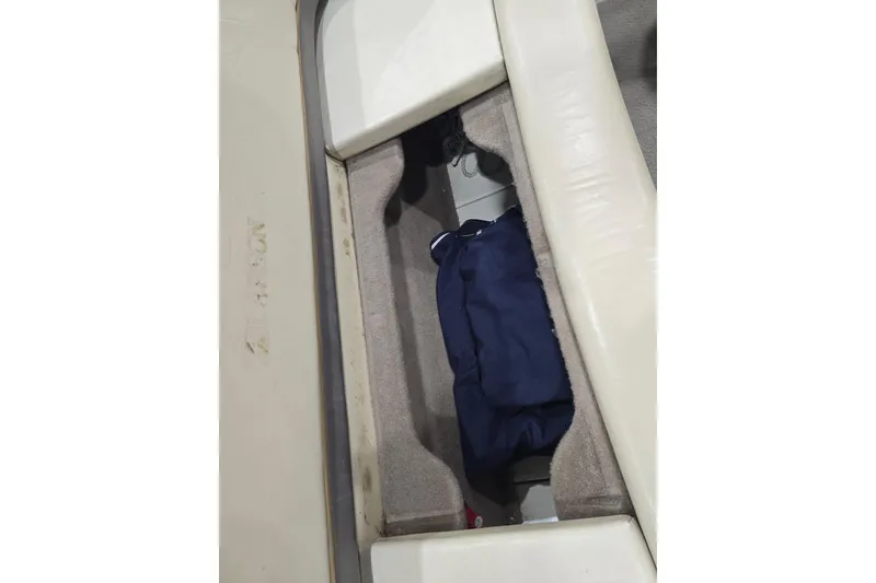 Slide: The Image of 2004 Larson LXi 190 boat storage compartment with blue bag inside. - 29