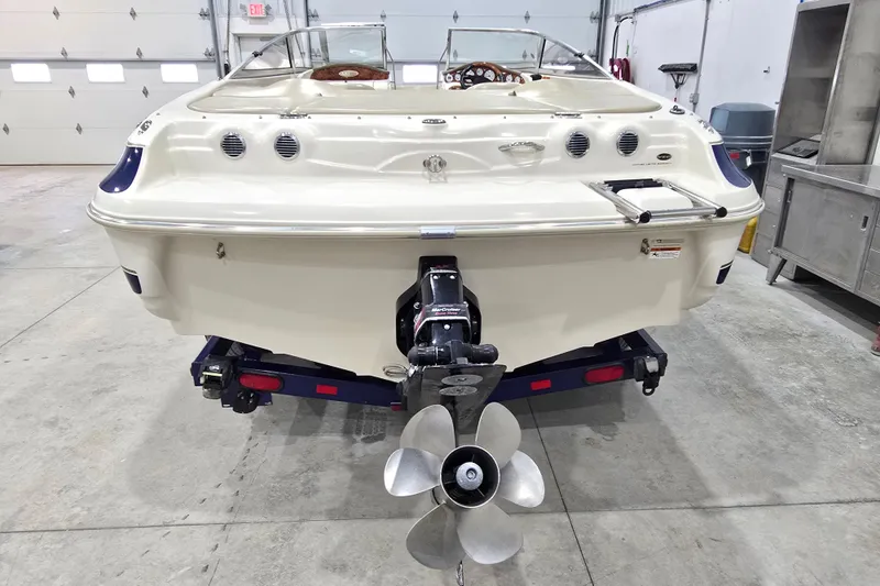 Slide: The Image of 2004 Larson LXi 190 boat in garage, rear view with propeller visible. - 3