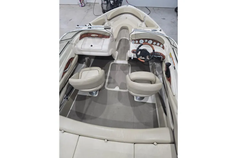 Slide: The Image of 2004 Larson LXi 190 boat interior with beige seating and dashboard controls. - 32