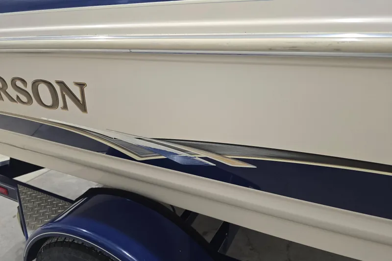Slide: The Image of 2004 Larson LXi 190 boat side view with decorative graphics and trailer. - 9