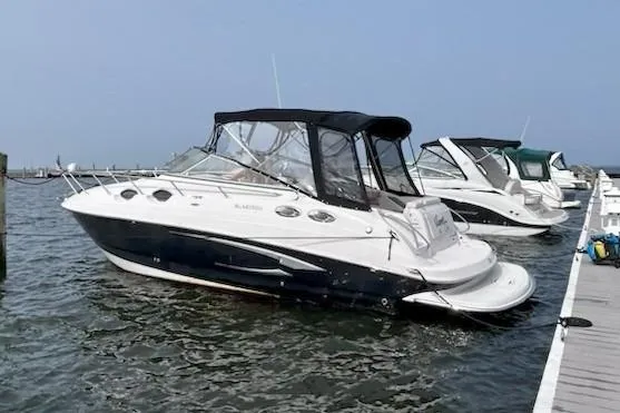 The Image of 2013 Glastron GS 289 boat docked at marina, featuring sleek design and black canopy. - 0