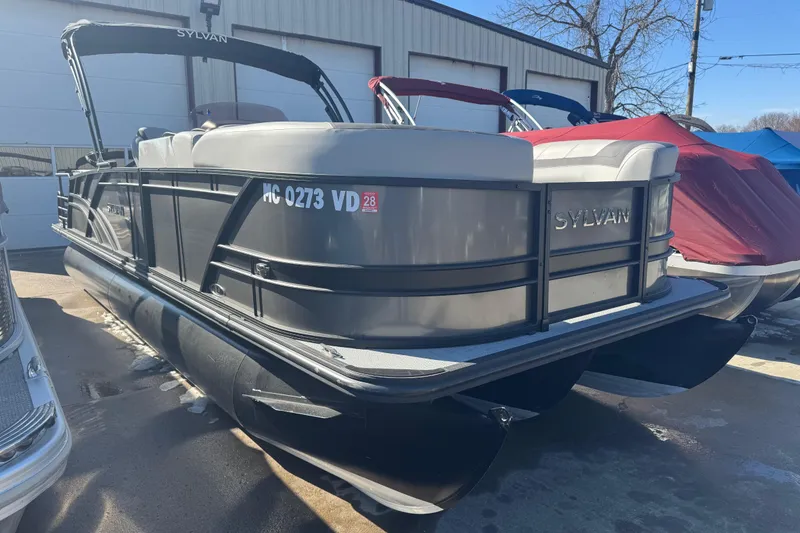 Slide: The Image of 2025 Sylvan L3 DLZ pontoon boat parked outdoors, showcasing sleek design and modern features. - 2