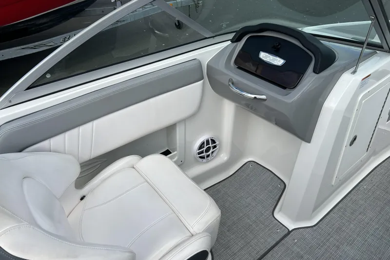 Slide: The Image of Interior of 2021 Chaparral 19 SSi boat, featuring white seating and modern dashboard. - 16