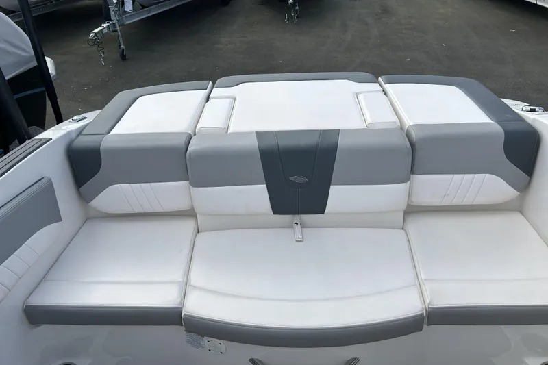 Slide: The Image of 2021 Chaparral 19 SSi boat with gray and white seating, docked on pavement. - 19