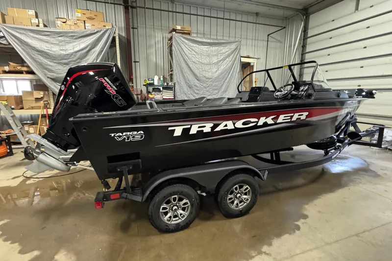 The Image of 2026 Tracker Targa V-19 Combo boat in a garage, featuring a sleek black design. - 0