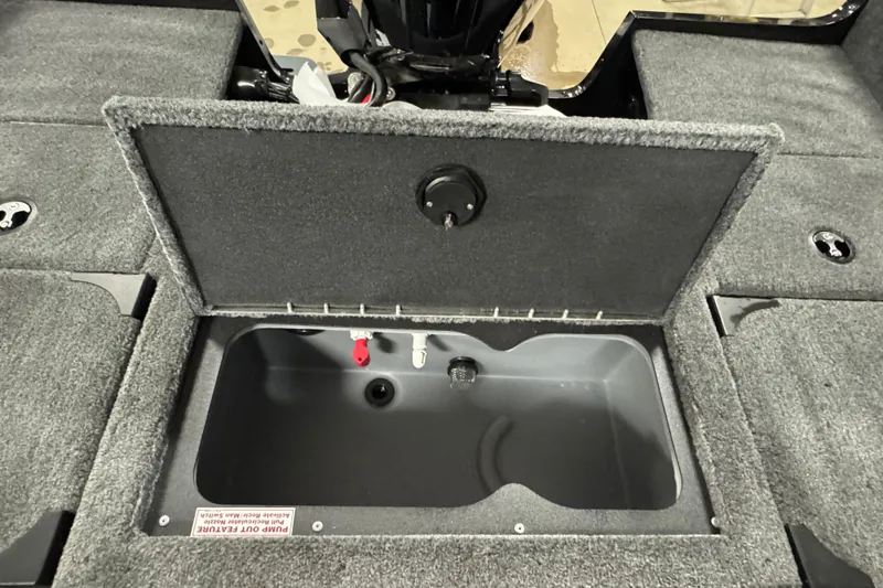 Slide: The Image of 2026 Tracker Targa V-19 Combo boat storage compartment with open lid, showing interior details. - 16