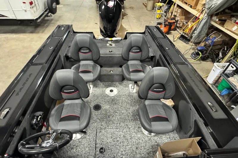 Slide: The Image of 2026 Tracker Targa V-19 Combo boat interior with four gray seats in a garage setting. - 20