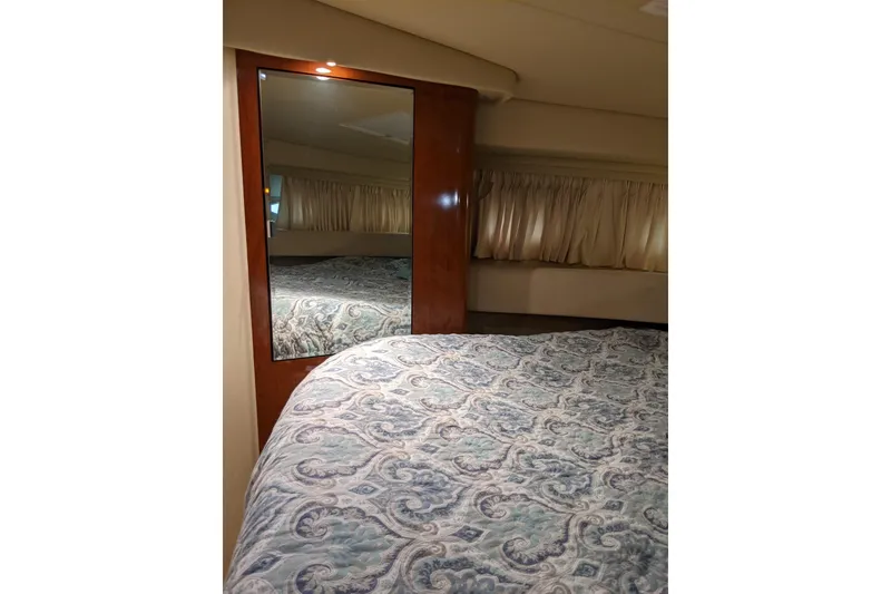 Slide: The Image of Interior cabin of 2004 Sea Ray 380 Sundancer with patterned bedding and mirror. - 22