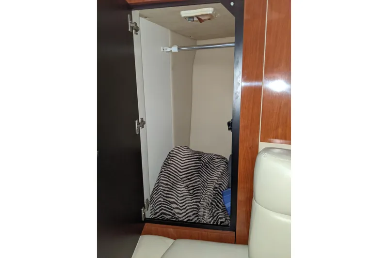 Slide: The Image of Open closet in 2004 Sea Ray 380 Sundancer with striped blanket inside. - 24