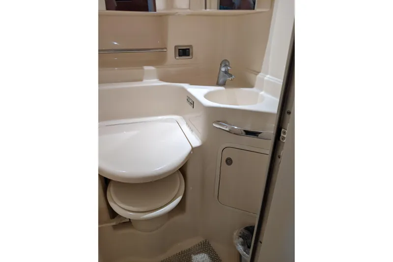 Slide: The Image of Bathroom interior of 2004 Sea Ray 380 Sundancer yacht, featuring sink and toilet. - 26