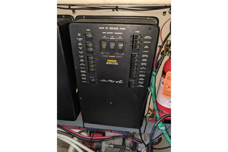 Slide: The Image of Main DC breaker panel on 2004 Sea Ray 380 Sundancer boat, with fire extinguisher nearby. - 35