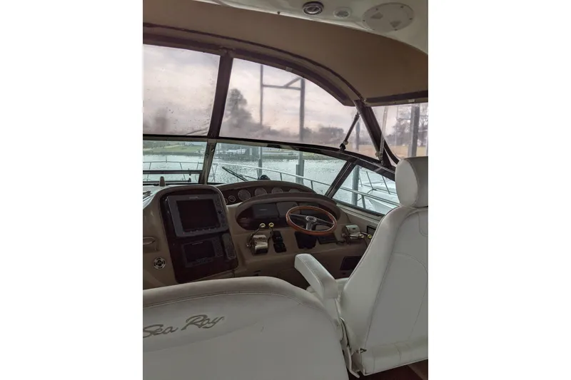 Slide: The Image of 2004 Sea Ray 380 Sundancer helm with steering wheel and navigation controls. - 7