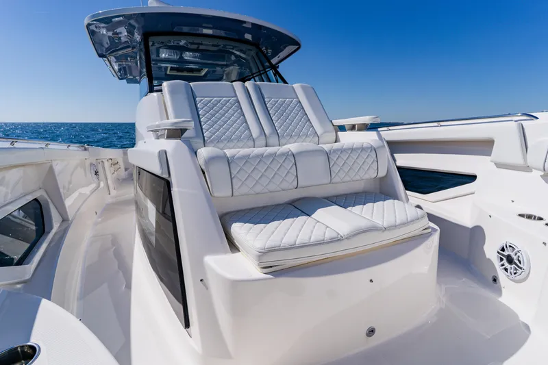Slide: The Image of 2022 Pursuit S 378 Sport boat with luxurious seating and ocean backdrop. - 16