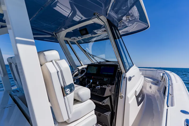 Slide: The Image of 2022 Pursuit S 378 Sport boat interior with helm, ocean view, and blue sky. - 23