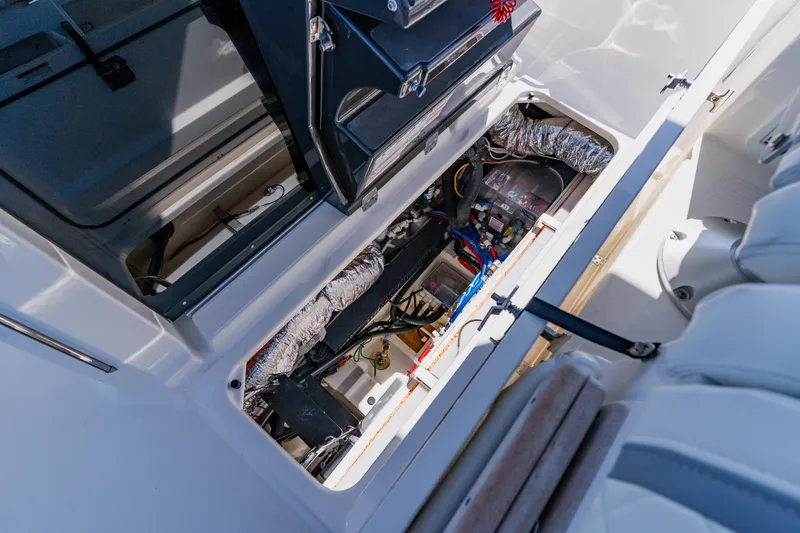 Slide: The Image of 2022 Pursuit S 378 Sport boat interior showing open storage compartment and wiring. - 33