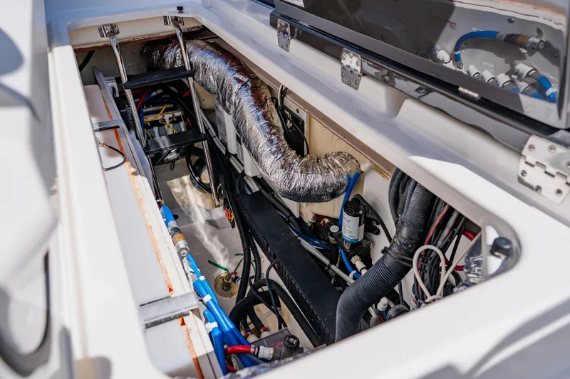 Slide: The Image of 2022 Pursuit S 378 Sport boat engine compartment with visible wiring and components. - 34