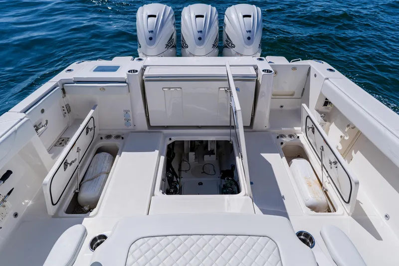 Slide: The Image of 2022 Pursuit S 378 Sport boat deck with storage compartments and triple engines. - 38