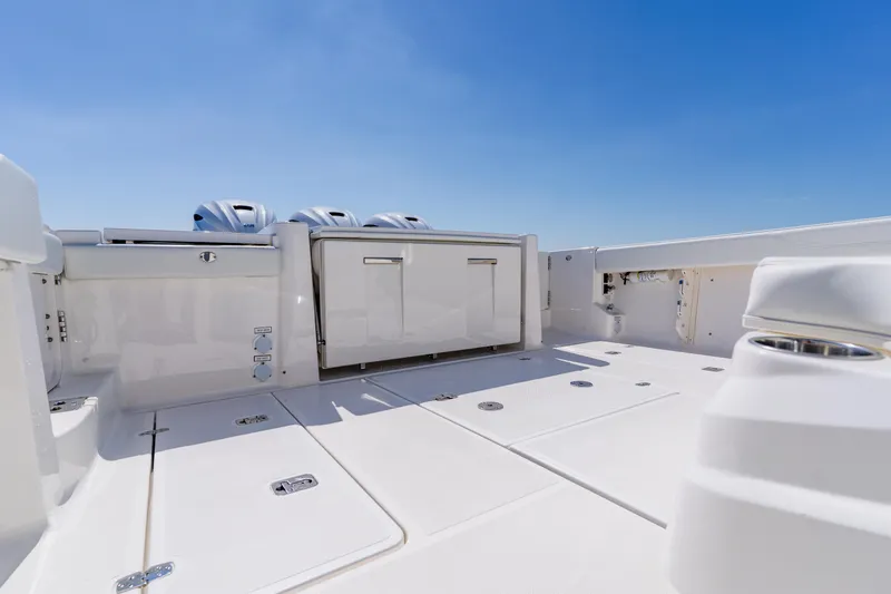 Slide: The Image of 2022 Pursuit S 378 Sport boat deck with storage and engines under clear sky. - 41