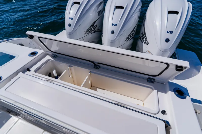 Slide: The Image of 2022 Pursuit S 378 Sport boat with open storage compartment and triple Yamaha V8 engines. - 47