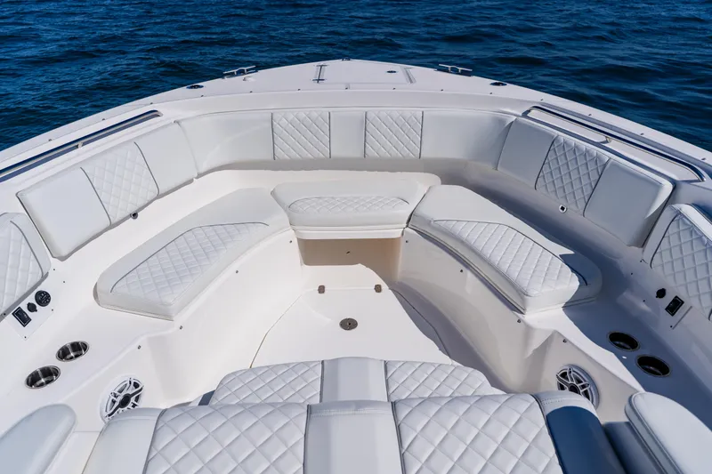 Slide: The Image of 2022 Pursuit S 378 Sport boat interior with luxurious white seating and ocean backdrop. - 9