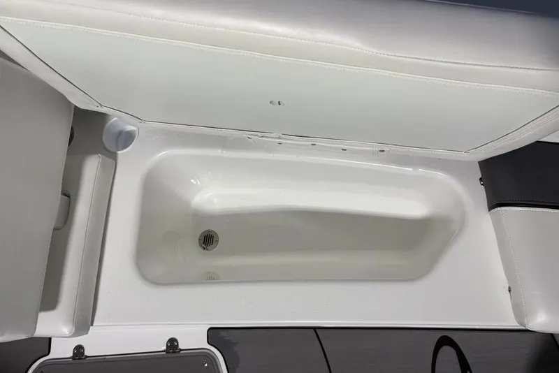 Slide: The Image of 2026 Tahoe T16 boat storage compartment with white interior and drain. - 8