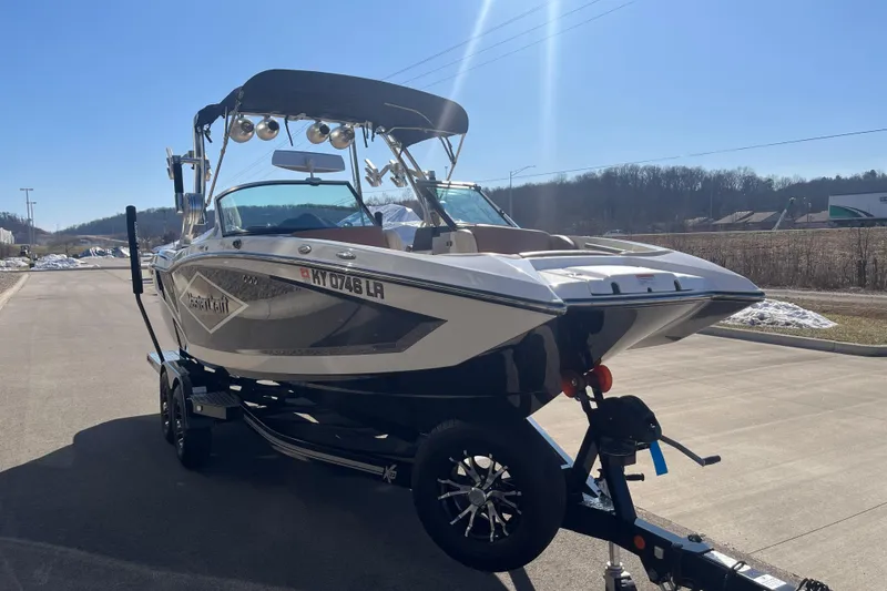 Slide: The Image of 2016 MasterCraft X23 boat on trailer, parked on sunny day, showcasing sleek design. - 5