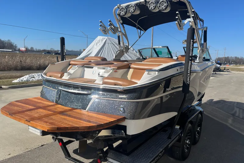 Slide: The Image of 2016 MasterCraft X23 boat with sleek design and wooden swim platform on a trailer. - 6