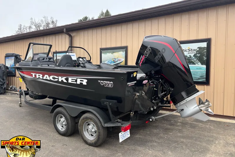 Slide: The Image of 2026 Tracker Targa V-18 WT boat on trailer, parked outside a building. - 2