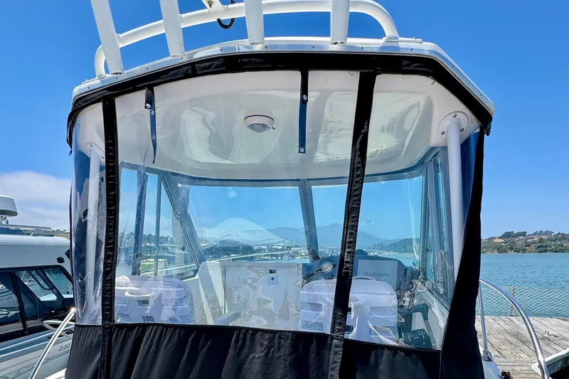Slide: The Image of 2013 Seaswirl Striper 2601 Walkaround O/B boat with enclosed cockpit, docked by the water. - 10