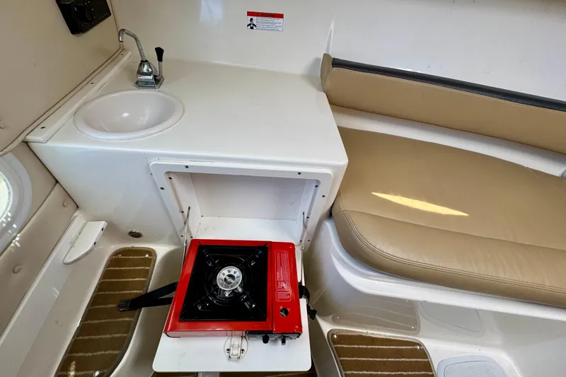 Slide: The Image of 2013 Seaswirl Striper 2601 Walkaround O/B interior with sink, stove, and seating area. - 6