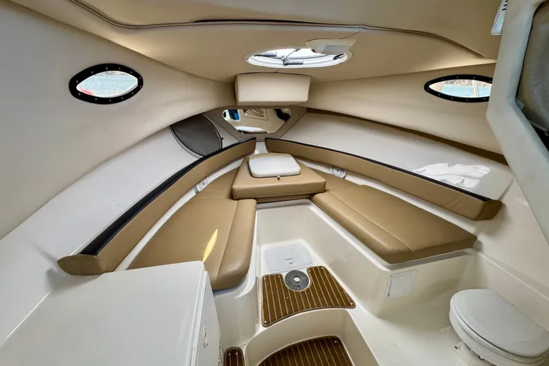 Slide: The Image of 2013 Seaswirl Striper 2601 Walkaround O/B cabin interior with beige seating and portholes. - 7