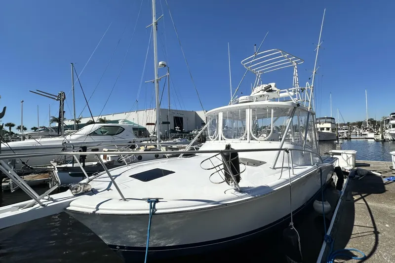 The Image of 1997 Luhrs 32 Open boat docked at marina under clear blue sky. - 1